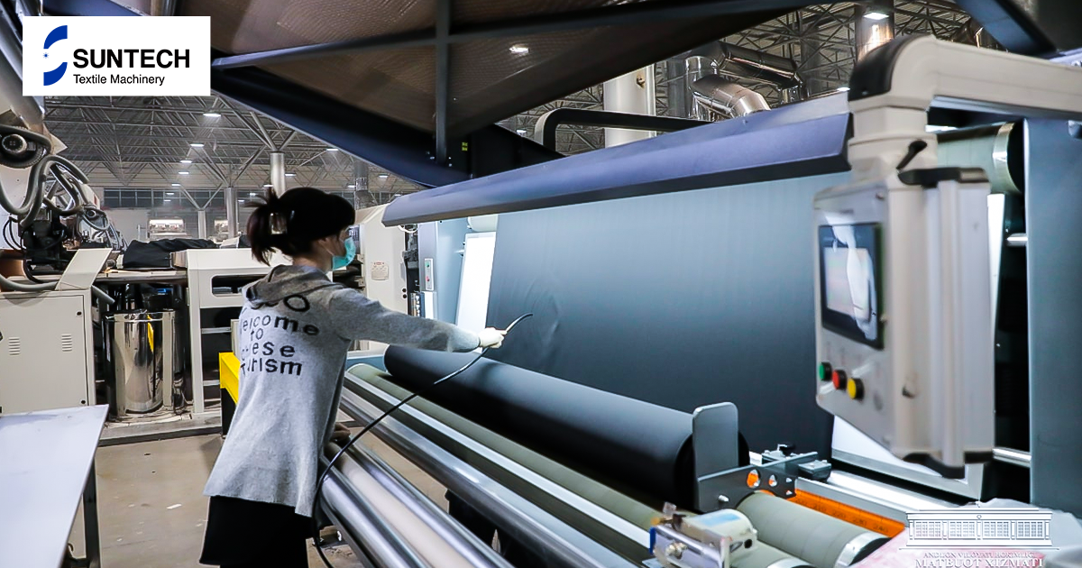 A worker is operating a fabric inspection machine