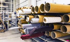 Rolls of fabric stored on racks in a textile factory or warehouse